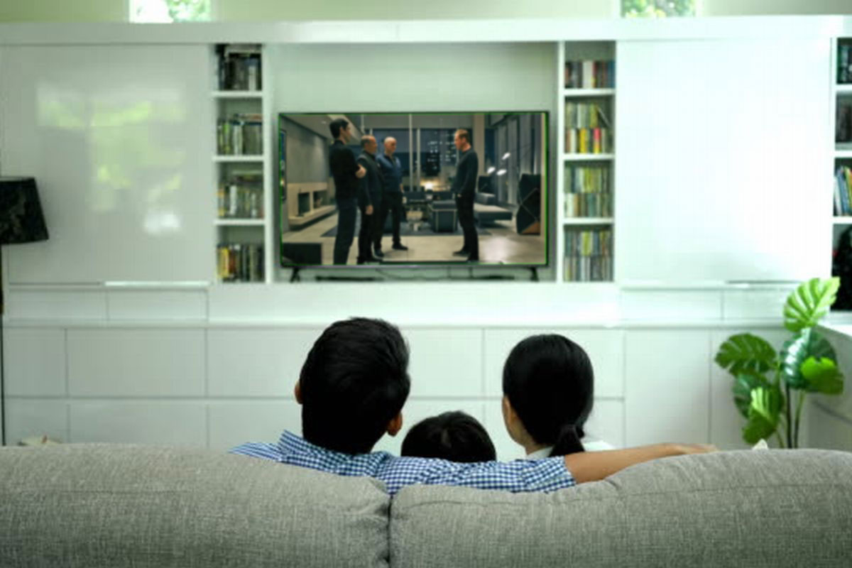 Uma família assistindo TV digital ilustra nosso artigo sobre: Como melhorar a qualidade do sinal da TV digital.