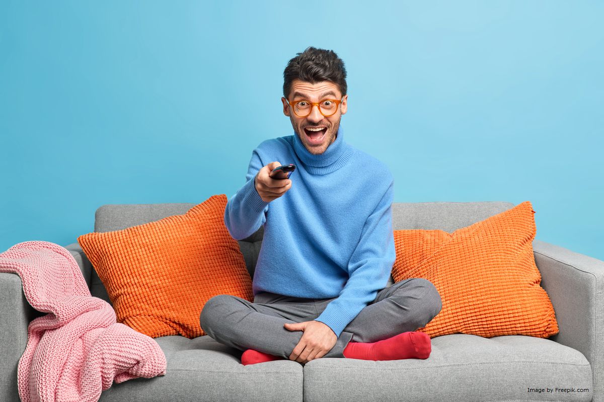 Um homem usando o controle remoto ilustra nosso artigo sobre: Como escolher o controle remoto certo para sua TV. Image by Freepik.com.