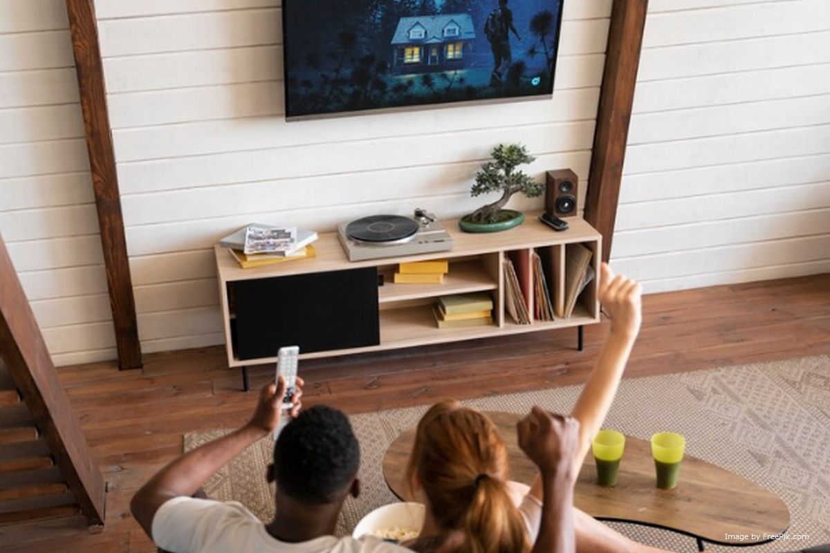 Um casal assistindo TV box ilustra nosso artigo sobre: Como funciona a tecnologia da TV Box